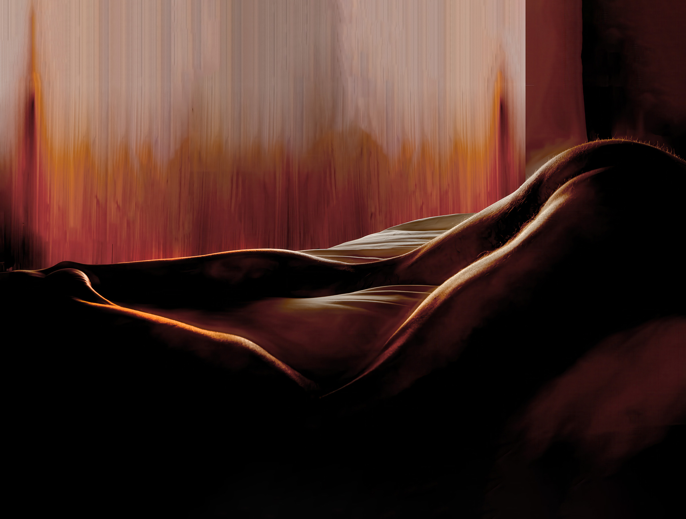 Male self-portrait combining photography and pastels, showing a reclining nude figure emerging from deep shadow. Warm amber and red light traces the curves of the body against an abstract, vertically brushed background of glowing earth tones, blending the human form with a landscape-like field of light and color.