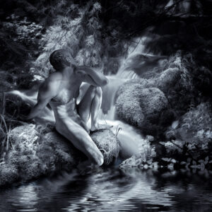 Black-and-white infrared photograph of a nude male figure seated on a mossy rock beside a small forest waterfall and pond. He is shown in profile with one knee raised, his head turned toward the falling water. Pale, luminous foliage surrounds him, while the curving waterfall and its reflection echo the lines of his body against deep woodland shadows.
